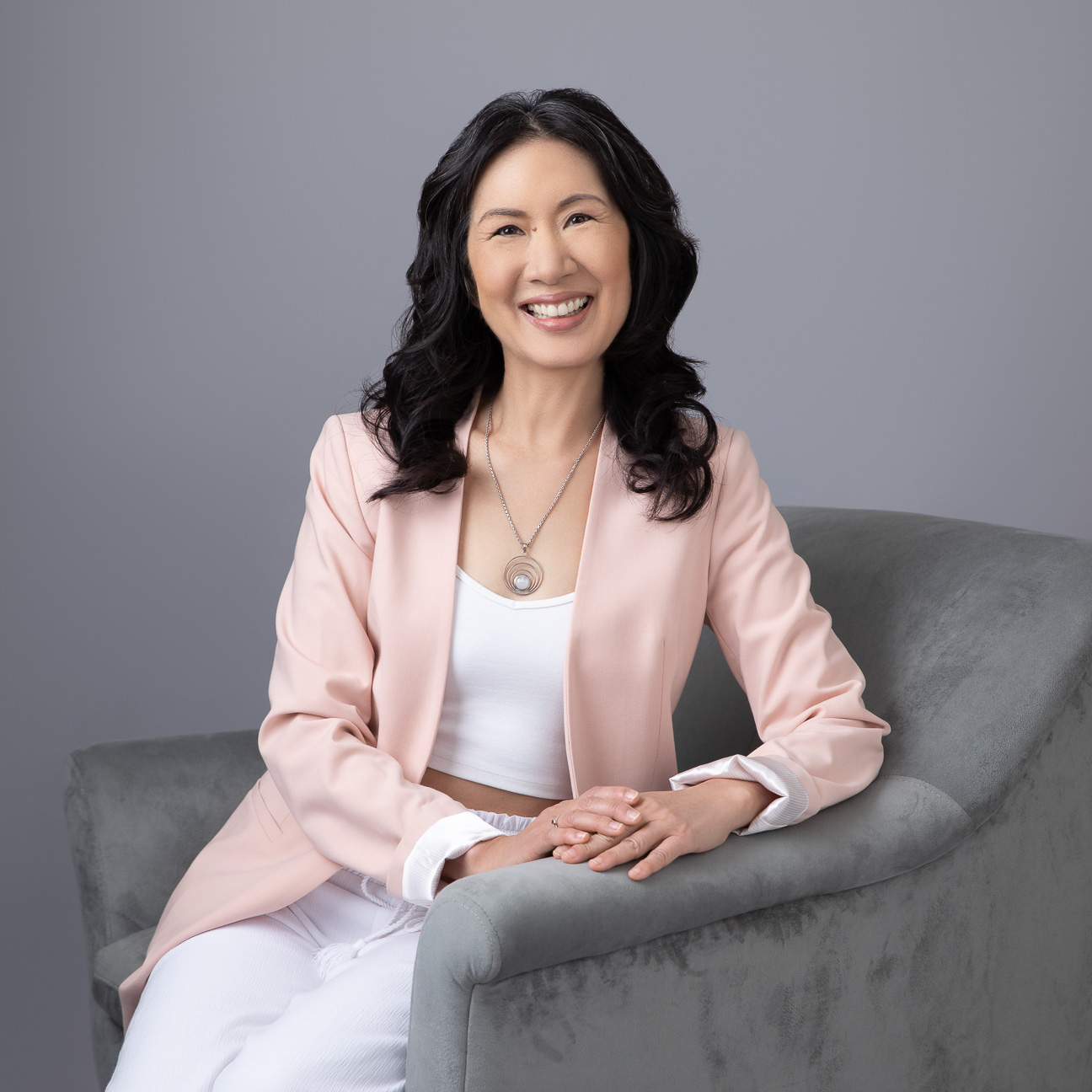 Jerilyn Ito seated in a soft pink blazer